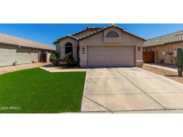 Charming single-story home with a neutral color palette, well-manicured lawn, and two-car garage at 15231 W Melissa Ln, Surprise, AZ 85374