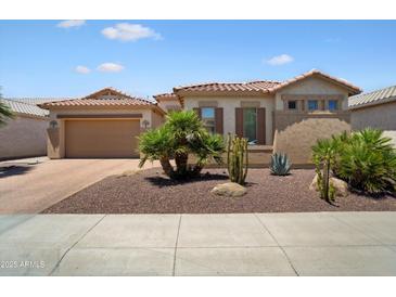 Charming single-story home featuring desert landscaping, a tile roof, and an attached two-car garage at 18242 W Stinson Dr, Surprise, AZ 85374