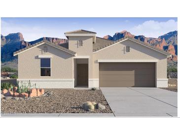 Inviting single-story home boasting desert landscaping, a two-car garage and neutral color palette at 2118 W Starfire Ave, Apache Junction, AZ 85120