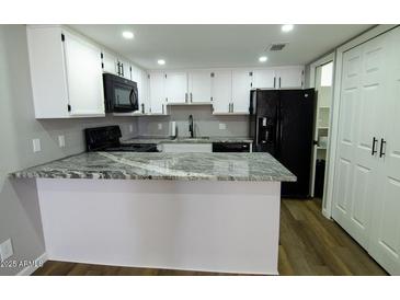 Updated kitchen features sleek, granite countertops, modern appliances and white cabinetry at 2144 E Center Ln # 3, Tempe, AZ 85281