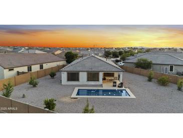This home has a backyard with a small pool, rock landscaping and a covered patio at 21797 N 259Th Ave, Buckeye, AZ 85396