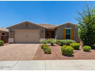 Charming single-story home featuring a desert landscaped front yard, two car garage, and colorful flower bushes at 31324 N 26 Glen Gln, Phoenix, AZ 85085