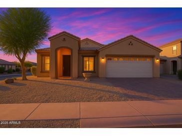 Charming single-story home featuring a two-car garage, desert landscaping, and a covered entryway at dusk at 3438 W Little Hopi Dr, Phoenix, AZ 85086