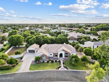 Expansive single-story home featuring a lush green lawn, mature trees, a tile roof, and an attached three car garage at 4040 E Mclellan Rd # 16, Mesa, AZ 85205
