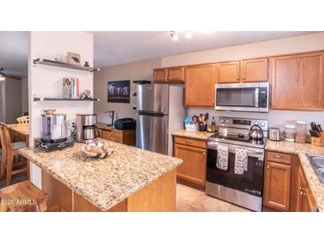 Well-lit kitchen features stainless steel appliances and a beautiful granite countertop island at 455 S Mesa Dr # 104, Mesa, AZ 85210