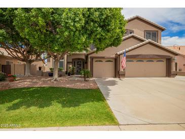 Charming two-story home with a well-manicured lawn, mature tree and a three car garage at 6862 W Honeysuckle Dr, Peoria, AZ 85383