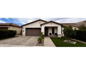 Charming single-story home with a well-manicured lawn, inviting entryway and a two car garage at 6947 W Spur Dr, Peoria, AZ 85383