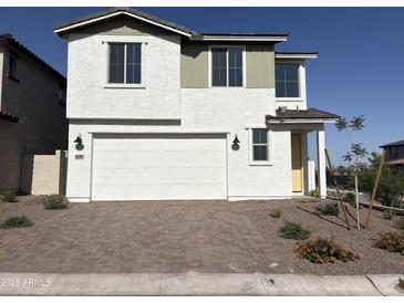 Charming two-story home with a white exterior, a two-car garage, and a well manicured front yard at 18001 W Lupine Ave, Goodyear, AZ 85338
