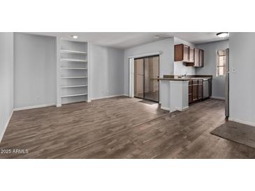 Inviting living room with built-in shelving and sliding glass doors for natural light, seamlessly connecting to the kitchen area at 747 S Extension Rd # 113, Mesa, AZ 85210