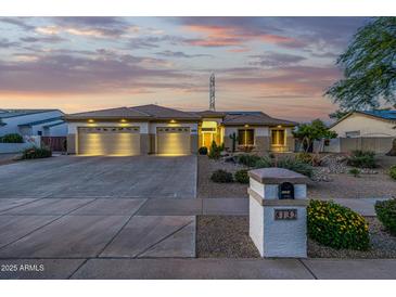 Charming single-story home boasts a three-car garage, desert landscaping, and a mailbox with the house number at 8132 W Hatfield Rd, Peoria, AZ 85383