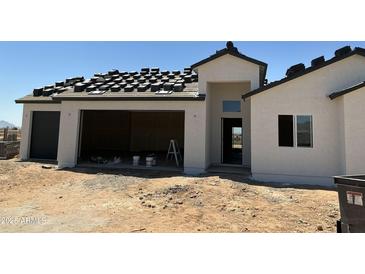 Exterior view of new construction with two-car garage with the roofing being installed at 9429 W Sandstone Mountain Dr, Casa Grande, AZ 85194