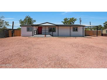 Charming single-story home features a red front door, metal overhang, and a gravel front yard for low maintenance appeal at 12810 N 20Th St, Phoenix, AZ 85022