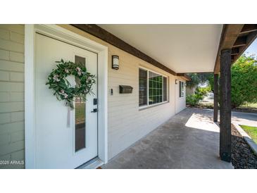 Inviting front porch featuring a white door adorned with a floral wreath at 1717 W Roma Ave, Phoenix, AZ 85015