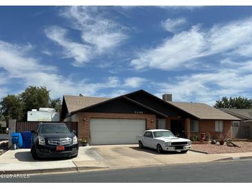 Charming single-story brick home with a two-car garage and a well-manicured lawn at 3106 E Grove Ave, Mesa, AZ 85204