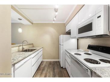 Well-lit kitchen with white cabinetry, modern appliances, and granite countertops at 3314 N 68Th St # W112, Scottsdale, AZ 85251