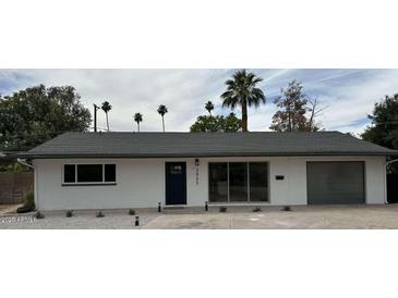 Charming single-story home featuring a low-pitch roof, freshly painted white exterior, and desert landscaping at 3933 E Flower St, Phoenix, AZ 85018