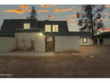 Charming townhouse featuring a gray roof, private front patio, and ample natural light from the upper windows at 8125 N 32Nd Dr, Phoenix, AZ 85051