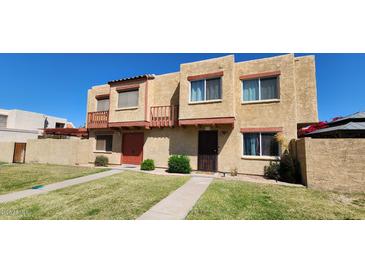A charming townhome featuring a stucco exterior, small balconies, and well-maintained landscaping at 948 S Alma School Rd # 71, Mesa, AZ 85210