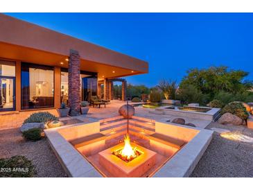 Inviting outdoor space featuring a modern fire pit, seating, and desert landscaping, perfect for evening relaxation and entertainment at 10267 E Cinder Cone Trl, Scottsdale, AZ 85262