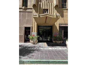 Orpheum Lofts entrance boasts a covered entrance, detailed architecture, and nearby shops in a vibrant city setting at 114 W Adams St # 302, Phoenix, AZ 85003