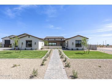 Inviting home featuring a neatly manicured lawn and a charming paved walkway, enhancing its curb appeal at 2087 N 77Th Pl, Mesa, AZ 85207