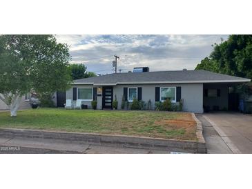 Charming single-story home with a well-maintained front yard, modern door, and a covered parking area at 3526 E Piccadilly Rd, Phoenix, AZ 85018