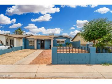 Charming blue single-story home with a well-kept front yard and black iron fence at 4219 W Pasadena Ave, Phoenix, AZ 85019