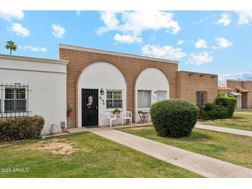 Charming single-story brick home featuring a well-manicured lawn and inviting front entry at 614 N Pioneer Cir, Mesa, AZ 85203