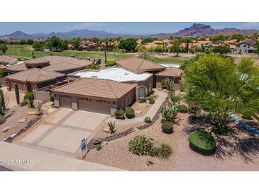 Beautiful desert home with tile roof, three car garage, and manicured landscaping with mountain views at 6162 E Redmont Dr, Mesa, AZ 85215