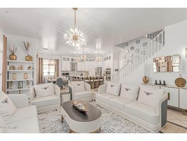 Bright living room with white sofas, chairs, a decorative rug, and a statement chandelier at 84 E Joseph Way, Gilbert, AZ 85295