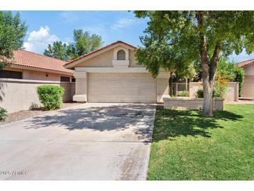 Charming single-story home with a two-car garage, a low maintenance yard and a well-kept lawn at 912 W Sunward Dr, Gilbert, AZ 85233