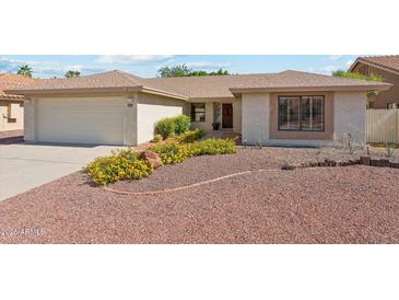 Charming single story home with a well-maintained front yard and attached two car garage at 9801 W Rockwood Dr, Peoria, AZ 85382