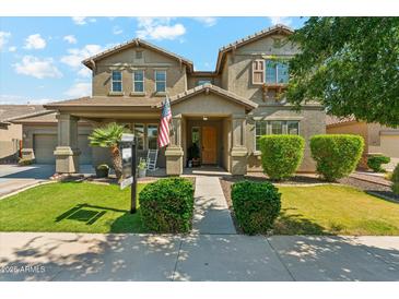 Charming two-story home with a landscaped front yard, inviting porch, and American flag at 14364 W Cameron Dr, Surprise, AZ 85379