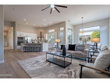 Bright, open-concept living room featuring modern decor, hardwood floors, and natural light at 19608 N Regents Park Dr, Surprise, AZ 85387