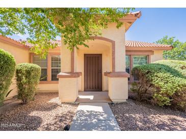 Inviting front entrance with a charming archway, beautiful landscaping and an attractive front door at 3665 E Thames Way, San Tan Valley, AZ 85140
