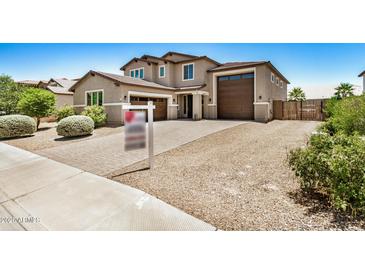 Two-story home featuring three-car garage, desert landscaping, and concrete driveway at 44157 W Palo Amarillo Rd, Maricopa, AZ 85138