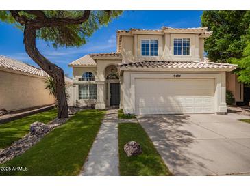 Inviting two-story home featuring a well-manicured lawn, desert landscaping, and a two-car garage at 4434 E Bannock St, Phoenix, AZ 85044