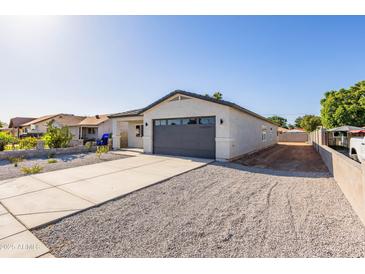 Charming single story home featuring a low maintenance yard, long driveway, and a gray color scheme at 9310 W Washington St, Tolleson, AZ 85353
