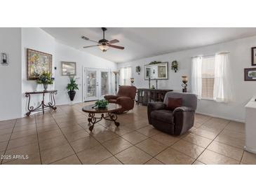 Bright living room with tile flooring, ceiling fan, comfortable seating, and lots of natural light at 10465 W Windsor Blvd, Glendale, AZ 85307