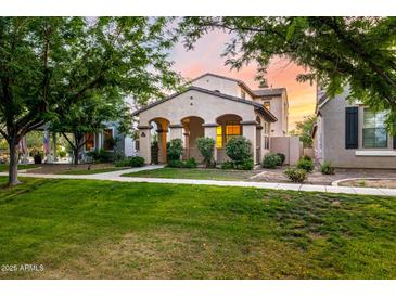 Charming home boasts desert landscaping, covered porch, and warm exterior lighting at 15469 W Dreyfus St, Surprise, AZ 85379