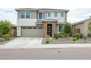 Charming two-story home with a stone-accented entryway, landscaped front yard, and attached two-car garage at 18813 W Solano Dr, Litchfield Park, AZ 85340