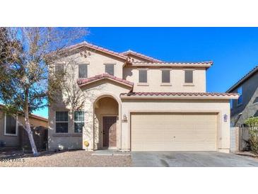 Charming two-story home with a red tile roof, arched entryway and a two car garage at 42468 W Palmyra Ct, Maricopa, AZ 85138