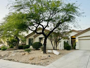 Charming home featuring desert landscaping with mature trees and a paved driveway at 7214 E Rustling Pass, Scottsdale, AZ 85255