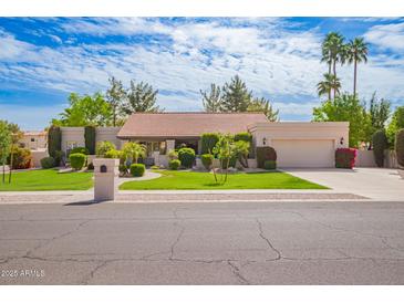 Charming single-story home with a well-manicured lawn, mature trees, and an attached two-car garage at 8851 S Juniper St, Tempe, AZ 85284