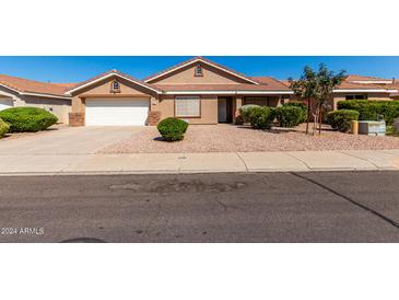 Charming single-story home featuring a well-manicured, low maintenance landscaped front yard and two-car garage at 1147 N Marvin St, Gilbert, AZ 85233