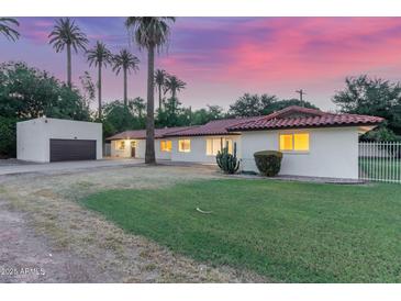 Charming single-story home with desert landscaping and a detached garage, complete with vibrant sunset backdrop at 1532 W Northern Ave, Phoenix, AZ 85021
