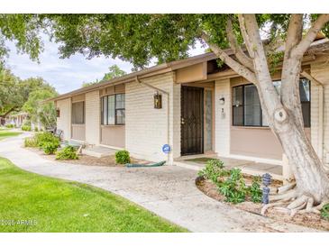 Charming single-story home featuring well-maintained landscaping, a security door and an inviting walkway at 1550 N Stapley Dr # 6, Mesa, AZ 85203