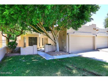 Charming home with mature shade tree, low stucco walls, and lush green grass at 1861 E Bendix Dr, Tempe, AZ 85283