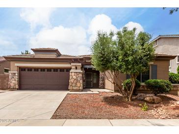 Charming single-story home with a stone-accented facade, a spacious driveway, and a well-maintained front yard at 18719 E Pelican Ct, Queen Creek, AZ 85142