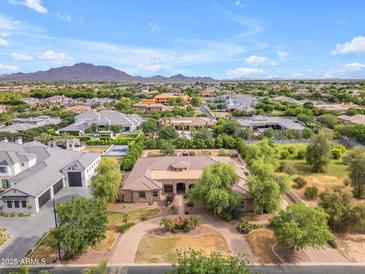 Expansive aerial view showcases lush landscaping, circular driveway, and mountain views at 2285 E Plum St, Gilbert, AZ 85298